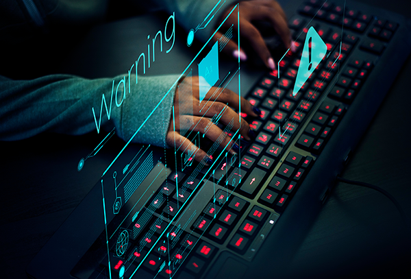 Person typing on a keyboard with holographic warning symbol, emphasizing cybersecurity risk or digital threat alert.