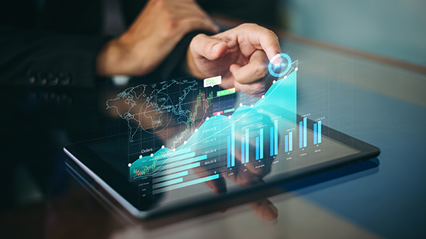 Person analyzing data with digital graphs on a tablet, featuring global map and charts for business insights.