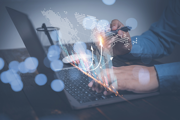 Person using laptop with digital world map and growth arrows, symbolizing global business and technology development.