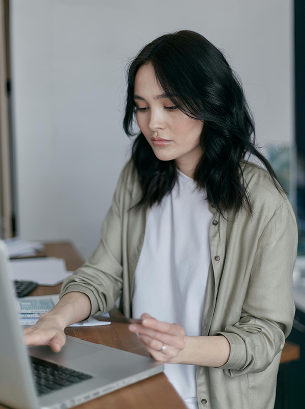 Person working on a laptop at a desk, focused and engaging in digital tasks.